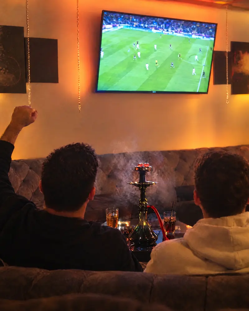 Freunde schauen Fussball auf dem TV in der KULT-Lounge